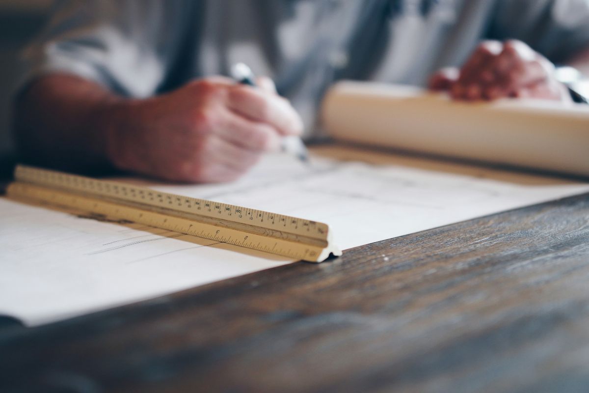 person drafting on blueprint